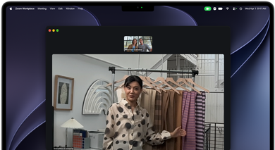 Una videollamada en un MacBook Pro en la que una mujer muestra telas a otras dos personas, la prestación Encuadre Centrado la mantiene en el encuadre conforme se desplaza